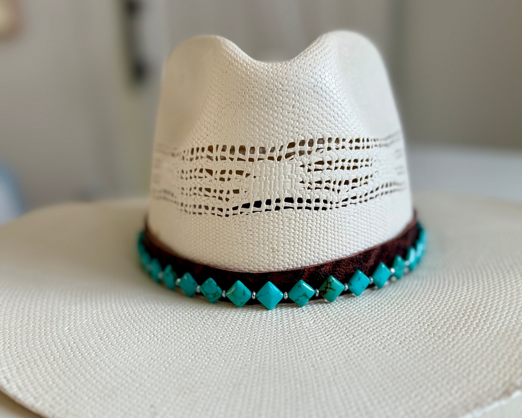 White straw hat with a turquoise band on a light background